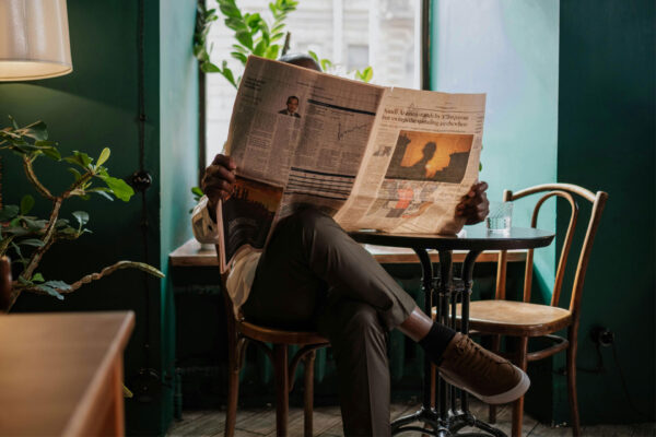 Ein Mensch in einem Café, Zeitung lesend